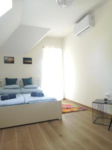 biała sypialnia z łóżkiem i oknem w obiekcie Forest House Balaton w mieście Cserszegtomaj