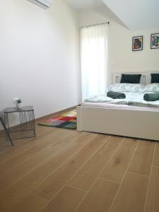 sypialnia z łóżkiem i drewnianą podłogą w obiekcie Forest House Balaton w mieście Cserszegtomaj
