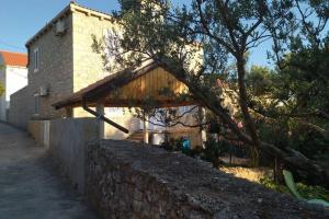 a house with a stone wall next to a building at Stonehouse on peaceful Island of Unije in Unije