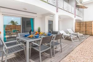 a dining room with a table and chairs on a patio at BLUE WAVE - 2 bedrooms - Orient Beach! in Orient Bay
