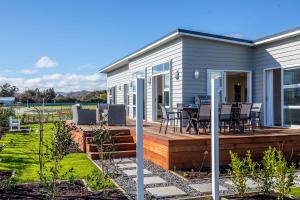 a house with a deck with a table and chairs at Three on Wilson in Martinborough 