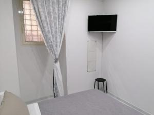 um quarto com uma cama e uma televisão na parede em [Centro Storico] Casa Elegante per Famiglia em Nápoles
