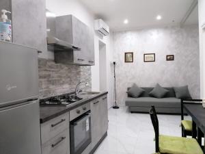 uma cozinha com um fogão e um sofá num quarto em [Centro Storico] Casa Elegante per Famiglia em Nápoles