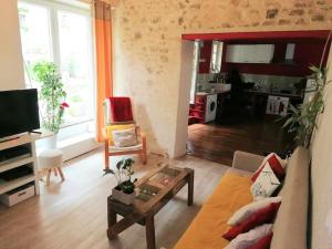 a living room with a couch and a table at Appartement rouge avec jardin in Eymoutiers