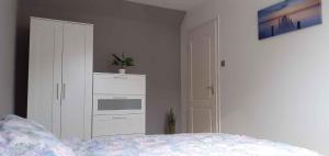 バラトンベレーニにあるHoliday home Balatonbereny/Balaton 18110のベッドルーム1室(ベッド1台、白いキャビネット付)