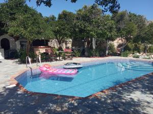 a swimming pool with a pink inflatable raft and an inflatable at Εlegant Villa Liakos in Pigi