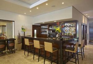 a bar in a room with chairs and a counter at HY BEACH FLATS - INTERNATIONAL in Recife