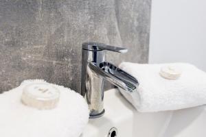 a bathroom sink with a faucet and towels at Wrexham Central Stay Apartment Seven in Wrexham