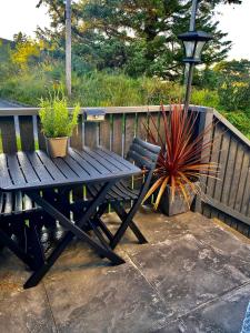 a wooden picnic table and a potted plant next to a fence at The Lodge Dunrowan in Kyle of Lochalsh