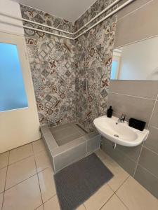 a bathroom with a sink and a shower at Lyrius Vendégház - Debrecen in Debrecen