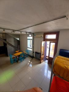 ein Wohnzimmer mit einem Tisch und ein Zimmer mit einem Bett in der Unterkunft High Hostel Rosario in Rosario