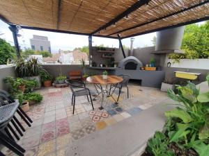a patio with a table and chairs and an outdoor kitchen at Lo de Pascuala -con cochera- in San Juan