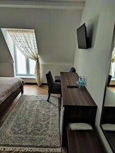 a bedroom with a desk and a bed and a window at Готель-ресторан "Олеся" in Berehove
