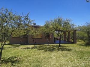 a house with a yard with trees in front of it at Luna de los Molles in Villa Las Rosas +6 photos