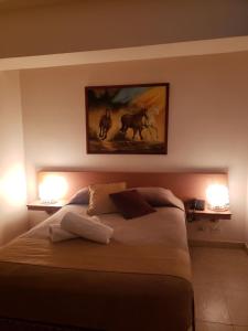 Hotel La Pequena Valencia في فالنسيا: غرفة نوم بسرير كبير وعليها مصباحين