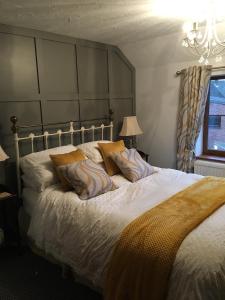 1 dormitorio con 1 cama grande y cabecero grande en The Elms, en East Harling