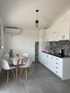a kitchen with a table and chairs in a room at Villa Dafina in Donji Štoj