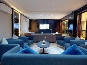 una sala de espera con sofás azules y una mesa en RAK Hotel Apartments en Yeda