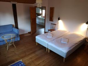 ein Schlafzimmer mit einem Bett, einem Stuhl und einem Tisch in der Unterkunft Wannborga Destilleri in Borgholm