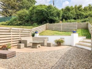 a patio with chairs and a table and a fence at 7 Harlyn Cottages in St Merryn