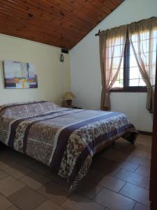 um quarto com uma cama e duas janelas em Casa cómoda en Barra del Chuy, Uruguay em Barra del Chuy