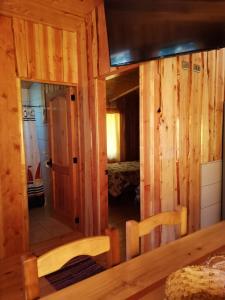 a wooden cabin with a large mirror in a room at Cabaña GAROVE in Panguipulli