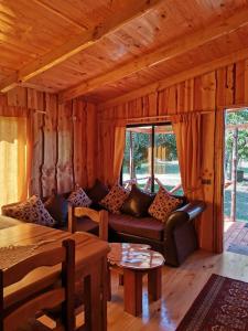 a living room with a couch and a table at Cabaña GAROVE in Panguipulli