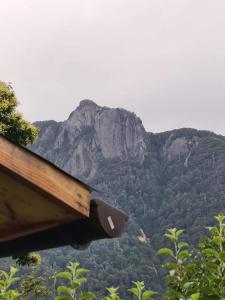 a view of a mountain with a building and trees at Cabaña GAROVE in Panguipulli