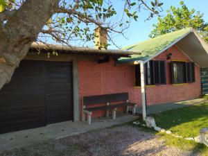 um banco em frente a uma casa com garagem em Casa cómoda en Barra del Chuy, Uruguay em Barra del Chuy