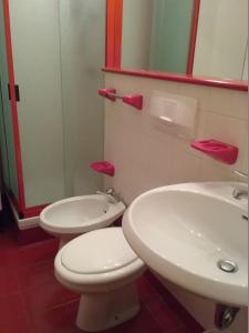 uma casa de banho com um WC branco e um lavatório. em Appartamento a CERVINIA - CIELOALTO em Breuil-Cervinia