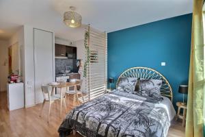 a bedroom with a blue wall and a bed and a table at # BIEN DORMIR à MULHOUSE # L'OCEANIC # CENTRE VILLE # COSY # in Mulhouse