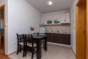 a kitchen with a table and chairs in a room at Apartments Janja in Trogir