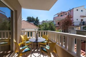 patio con mesa y sillas en el balcón en Apartments Janja, en Trogir