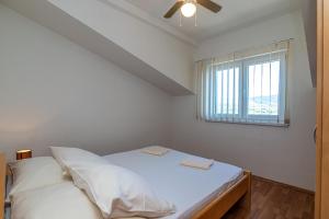 a bedroom with a bed with white sheets and a window at Apartments Janja in Trogir +127 photos