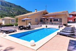 a villa with a swimming pool in front of a house at Villa Montesol in La Drova