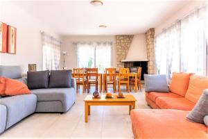 a living room with couches and a dining room at Villa Montesol in La Drova