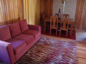 sala de estar con sofá y mesa en Cabañas Maroni, en Las Trancas