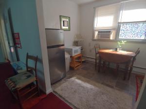 a kitchen with a stainless steel refrigerator and a table at Va Beach Zen tree house style studio F in Virginia Beach