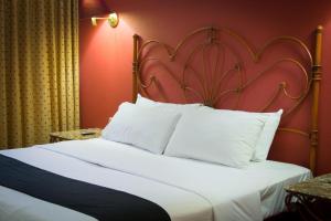 a bedroom with a large white bed with a red wall at Hotel Santa Maria in Mexico City