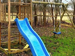a blue slide in a playground with a swing at 5 person holiday home in Dannemare in Dannemare