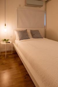 a white bed with two pillows and a table at Eilat vacation house דירות נופש אילת in Eilat