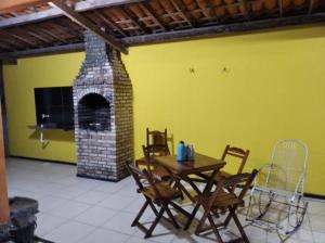 a dining room with a table and a brick fireplace at Casa em Paracuru Beach in Paracuru