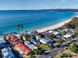 an aerial view of a beach with houses and the ocean at Neptune Hyams Beach in Hyams Beach