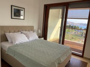 a bedroom with a bed with a view of a balcony at Bitcoin and Ethereum Deluxe Apartments in Bar