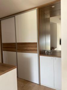 a kitchen with white cabinets and a mirror at Bitcoin and Ethereum Deluxe Apartments in Bar +55 photos