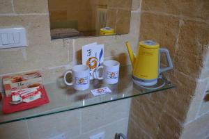 een glazen aanrecht met drie koffiemokken erop bij Depandance Economy in Manduria