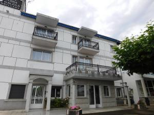 Un edificio blanco con dos balcones. en HOTEL TERRA GALEGA MEIGA, en Monforte de Lemos