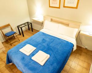1 dormitorio con 1 cama azul y 2 toallas en Departamento Moreno en Santa Rosa