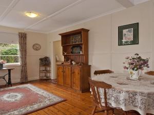 a dining room with a table and a cabinet at Hollyoak Cottage in Bowral