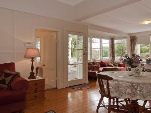 a living room with a table and a couch at Hollyoak Cottage in Bowral